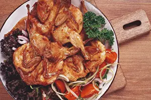 Baked quail, served on a plate with crispy lettuce leaves