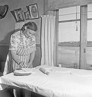 Baking bread 1949. Interior of a kitchen with a woman baking bread