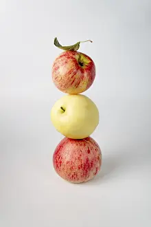 A balance of red and yellow apples on white