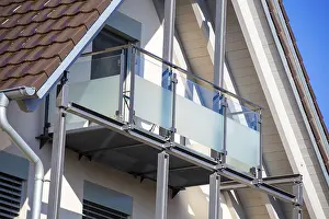 Balcony railing made of glass and stainless steel on a residential building