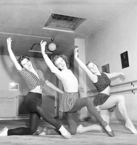 Ballet school in the 1940s. Three young dancers are practising their ballet in a ballet studio