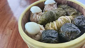 A bamboo steamer filled with diverse dim sum including Japanese siomai
