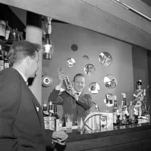 Bar in the 1950s. A bartender is mixing drinks behind the bar counter