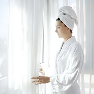 Category Historic EN Prints: Bathrobe happy woman sunny hotel window white curtains