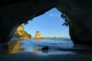 Beach and sea seen from a cave under a bright morning sky