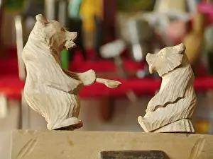 She bear feeds her cub, carved wooden toy