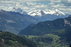 Beautiful aerial view of high snow-covered mountains and valley with village in Switzerland