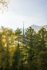 Beautiful Autumn Forest and Church Tower and Mountain and Sky with Sunlight in a Sunny Day in Bad Ragaz