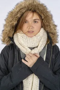 A beautiful blonde teenage model posing with a winter coat in a studio environment