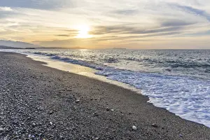 Beautiful coastline with a sandy beach and pebble beach at sunset