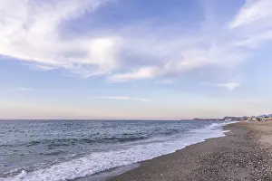 Beautiful coastline with a sandy beach and pebble beach at sunset