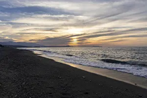 Beautiful coastline with a sandy beach and pebble beach at sunset