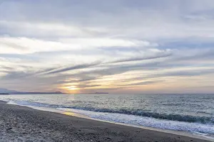 Beautiful coastline with a sandy beach and pebble beach at sunset