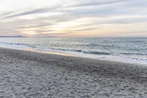 Beautiful coastline with a sandy beach and pebble beach at sunset