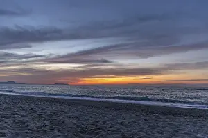 Beautiful coastline with a sandy beach and pebble beach at sunset