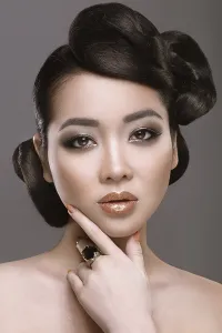 Beautiful girl with oriental type evening hair and makeup