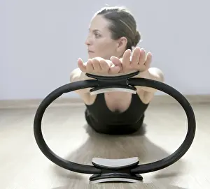 Beautiful instructor woman with magic pilates ring in sport gym