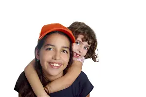 Beautiful Latin teen hispanic girl with little friend smiling isolated on white