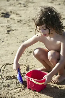 Beautiful little girl playing on the beach sand