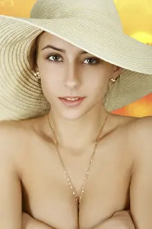 Beautiful luxury girl in straw hat on blurred sunset background