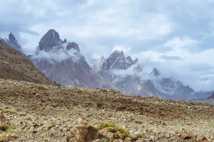 Beautiful peaks of Trango Towers surrounded by clouds in Karakoram Mountain Range in Pakistan