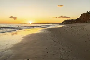 Beautiful sandy beach with red rocks and cliffs