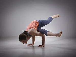 Beautiful sporty fit yogini woman practices yoga asana eka pada koundinyasana 1