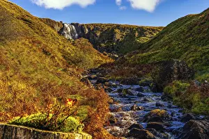 Beautiful waterfall and stream in the valley of Glenariff Forest Park in autumn colours