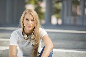Beautiful young woman with vintage music headphones around her neck