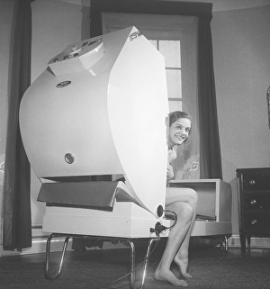 Beauty care in the 1950s. A young woman is sitting in a machine named Infra Thermo