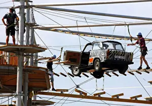 Berlin, 31.07.2010, Climbers balance over a Trabant suspended on ropes in the high ropes course Mount Mitte