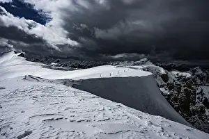 Berlinger Koepfl summit area with snow-covered mountains in the background and dramatic sky