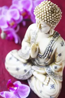 Bhudda Figurine With Orchids On A Red Background