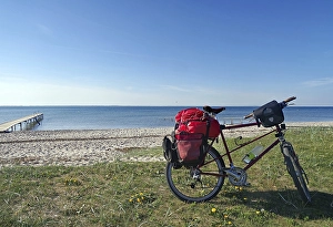 Category Scandinavia Prints: Bicycle with luggage in front of a lonely sandy beach with jetty