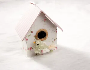 Bird in a nest fabric house with round window in pastel colors