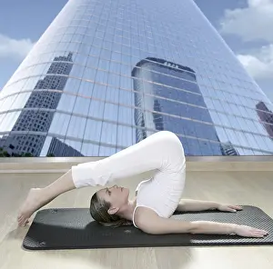 Black mat yoga woman window view of city urban buildings