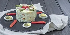 Black slate plate with ensaladilla rusa or Russian salad typical spanish tapa garnished with red bell pepper
