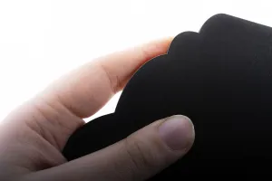 Black speech bubble shaped notice board in hand on white background