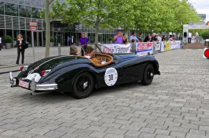 Black vintage convertible on event street with spectators
