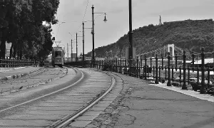 Black and white image of an old tram approaching on tram tracks in budapest