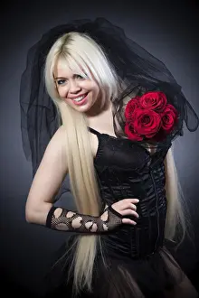 Black widow in grief with flowers with a veil on a black background