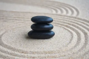 Black zen stones inside lines carved on sand with customizable space for text