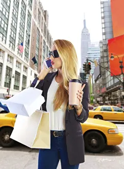 Blond girl shopaholic talking phone in fifth 5th avenue on New York Manhattan Photomount