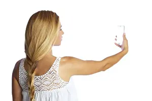 Blond tourist girl taking photos with smartphone on white background and braid