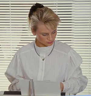 Blonde secretary sits at the typewriter