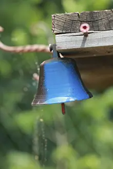 Blue bell hanging from a wooden post