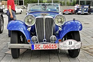 Blue classic classic car with distinctive headlights and nostalgic license plate