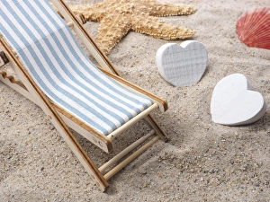 Blue deckchair with starfish in the sand on a beach