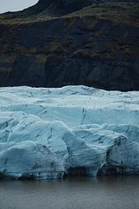 Blue glacier with dark mountainous background