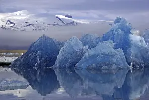 Blue iceberg reflected in calm water
